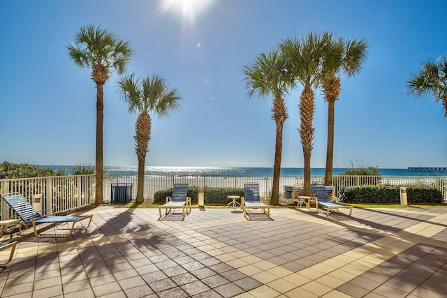 view of patio / terrace with a water view and fence