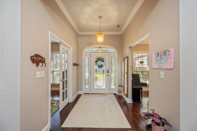 foyer featuring baseboards, a healthy amount of sunlight, dark wood finished floors, and crown molding