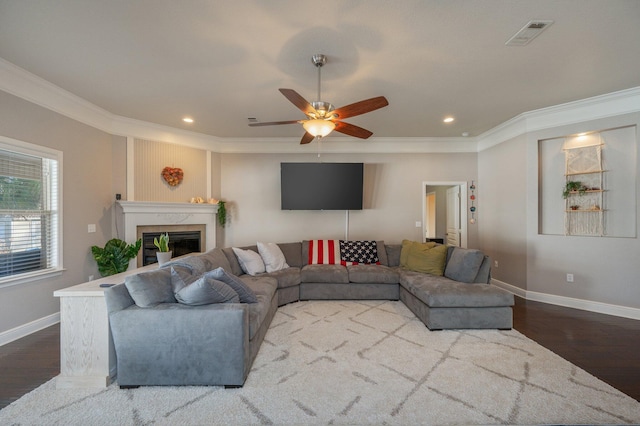 living area with dark wood-style floors, visible vents, baseboards, and a premium fireplace