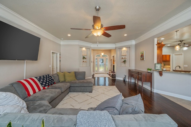 living room featuring ornamental molding, a ceiling fan, recessed lighting, baseboards, and dark wood-style flooring