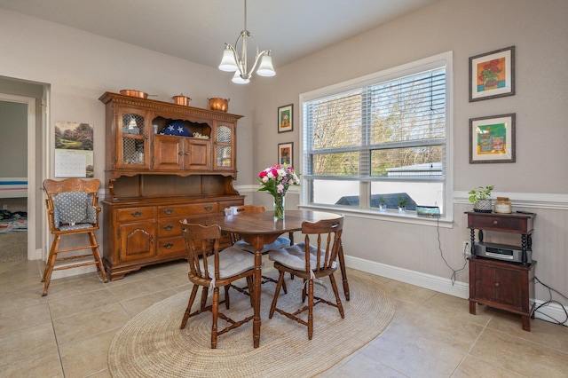 dining area with light tile patterned floors, baseboards, and a chandelier