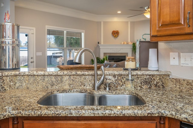 kitchen featuring a sink, light stone counters, and a healthy amount of sunlight