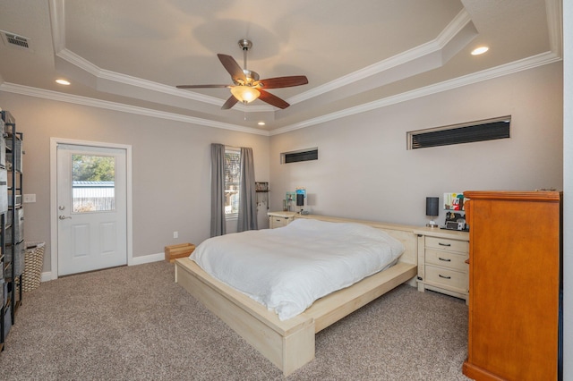 carpeted bedroom with a tray ceiling, visible vents, and crown molding