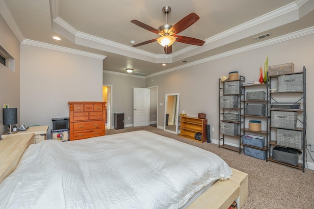 carpeted bedroom with visible vents, a raised ceiling, baseboards, and crown molding