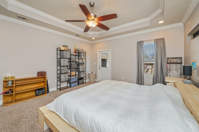 bedroom featuring visible vents, a tray ceiling, carpet flooring, crown molding, and baseboards