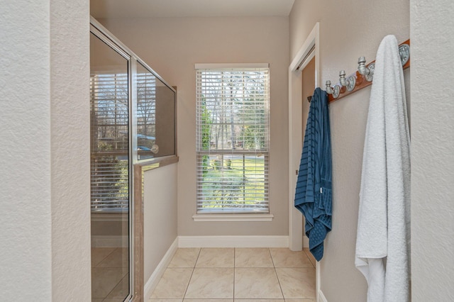 bathroom with tile patterned flooring, baseboards, and a wealth of natural light