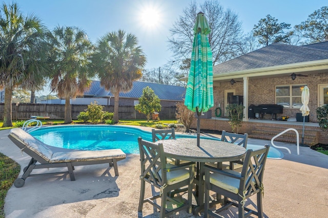 view of pool with a ceiling fan, fence, outdoor dining area, a fenced in pool, and a patio area