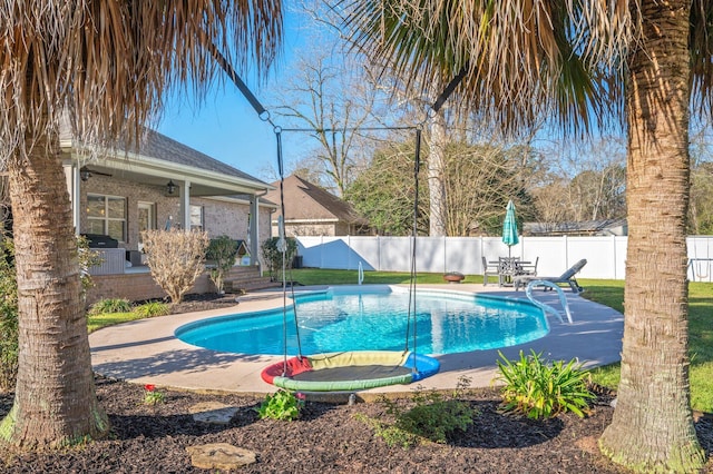 view of swimming pool featuring ceiling fan, a fenced in pool, a patio, and a fenced backyard