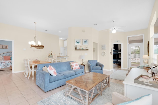 living room featuring light tile patterned floors, baseboards, and ceiling fan with notable chandelier