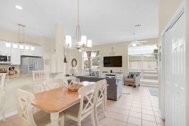 dining room with light tile patterned floors, visible vents, and ceiling fan with notable chandelier