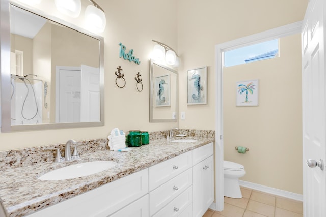 full bathroom with double vanity, toilet, a sink, and tile patterned floors