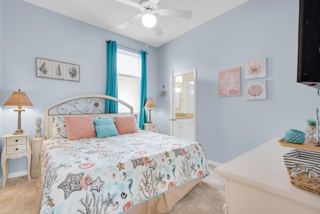 bedroom featuring a ceiling fan, light colored carpet, baseboards, and ensuite bathroom