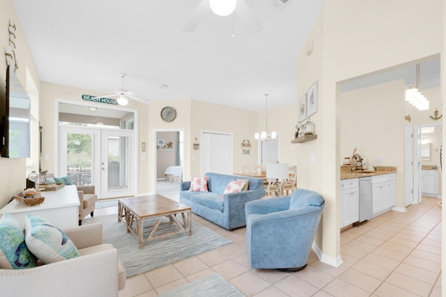 living room with ceiling fan with notable chandelier, french doors, baseboards, and light tile patterned floors