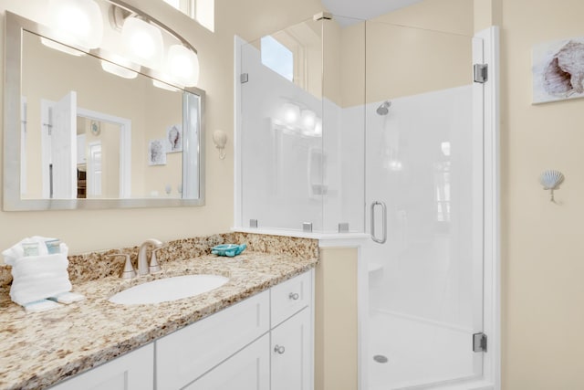 full bathroom featuring a stall shower, a healthy amount of sunlight, and vanity