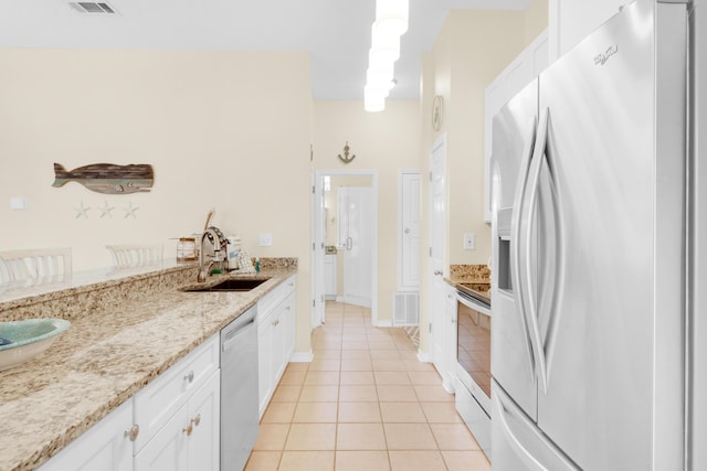 kitchen featuring visible vents, appliances with stainless steel finishes, white cabinets, a sink, and light tile patterned flooring