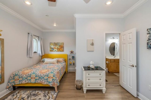 bedroom with recessed lighting, light wood-type flooring, baseboards, and crown molding