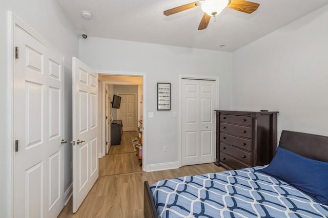 bedroom featuring light wood-type flooring, baseboards, a closet, and ceiling fan