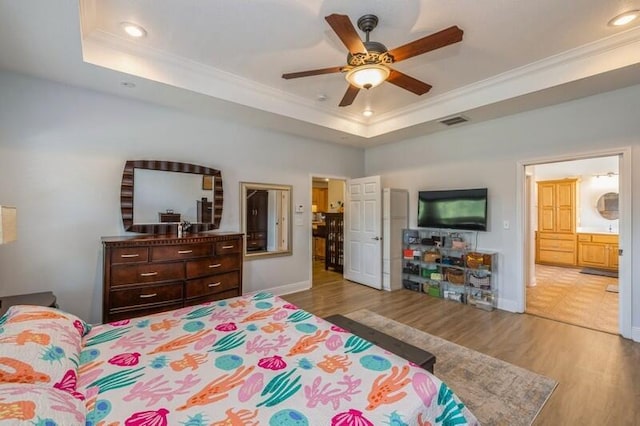 bedroom featuring recessed lighting, wood finished floors, a raised ceiling, and ornamental molding