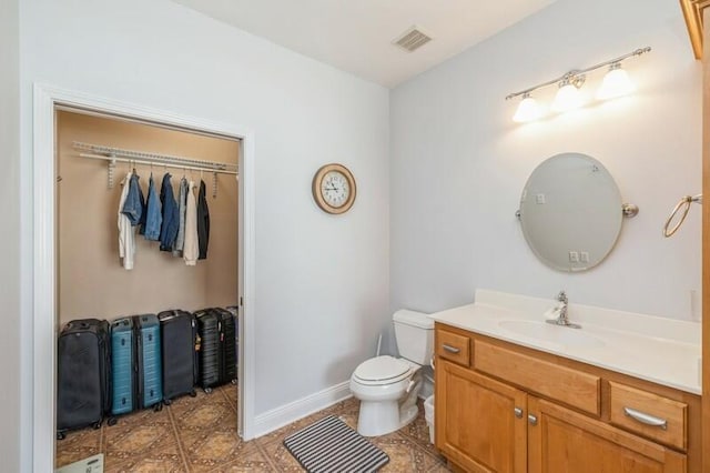 bathroom featuring visible vents, toilet, vanity, and tile patterned flooring