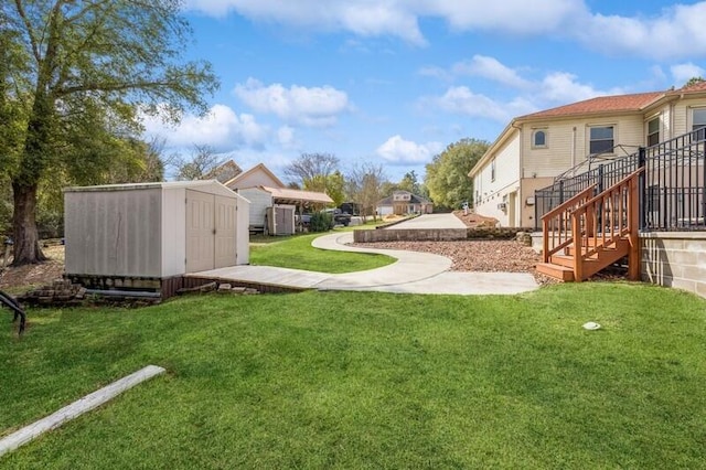 view of yard featuring an outdoor structure, stairway, a storage unit, and a residential view