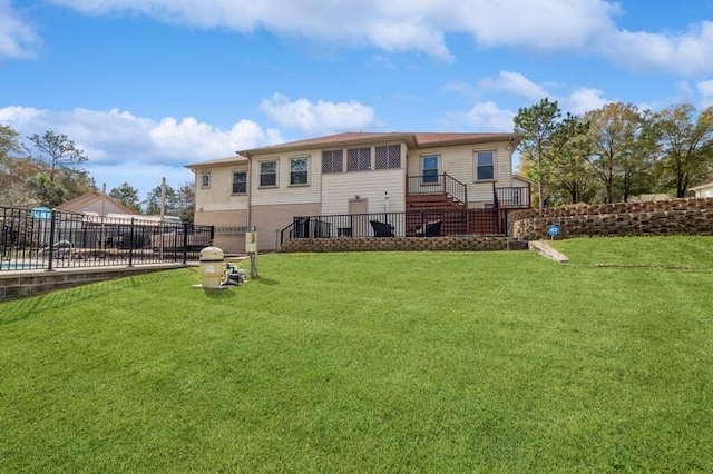 rear view of property featuring a yard and fence