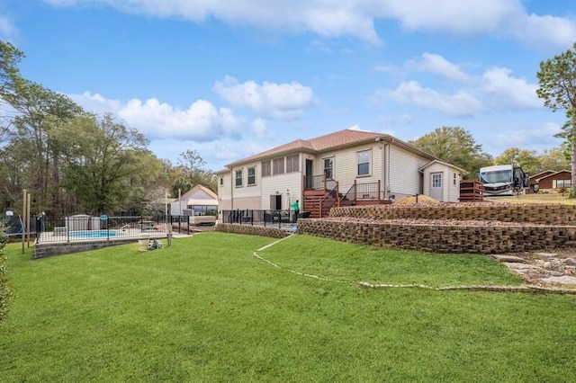 back of property with a yard, a fenced in pool, and fence