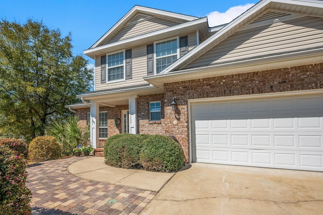 view of front facade with a garage, brick siding, and driveway