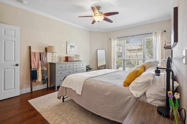 bedroom featuring dark wood finished floors, ceiling fan, baseboards, and ornamental molding