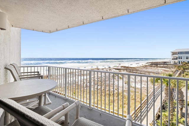 balcony featuring a water view and a beach view