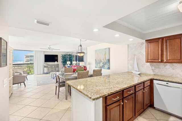 kitchen with tasteful backsplash, open floor plan, dishwasher, light tile patterned floors, and light stone counters