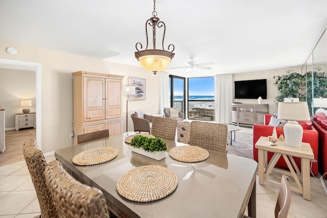 dining area featuring light tile patterned floors, baseboards, and ceiling fan