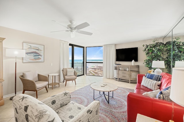 living area featuring light tile patterned flooring, a ceiling fan, baseboards, and expansive windows