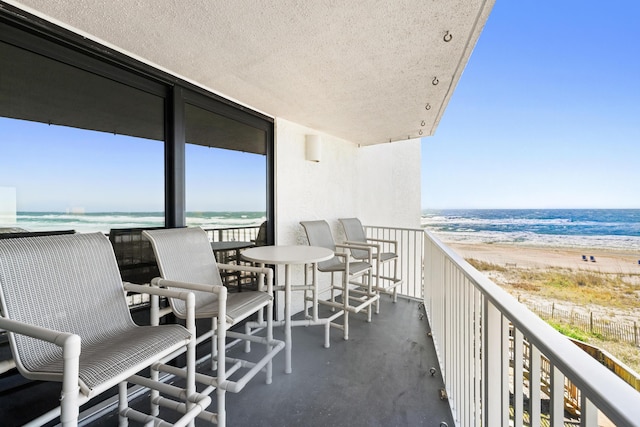 balcony featuring a water view and a view of the beach