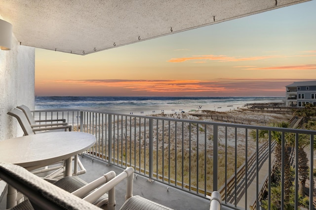 balcony featuring a view of the beach and a water view