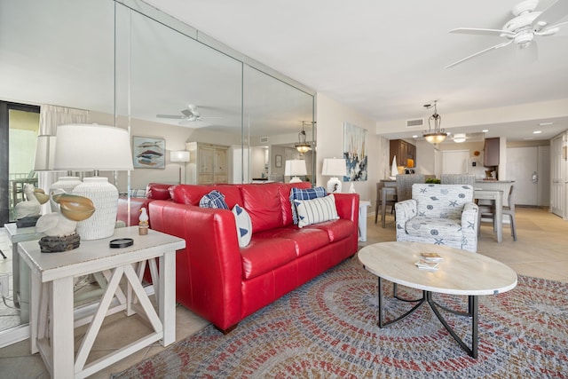 living room featuring light tile patterned floors, visible vents, and ceiling fan