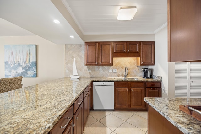 kitchen featuring backsplash, light stone countertops, dishwasher, light tile patterned flooring, and a sink