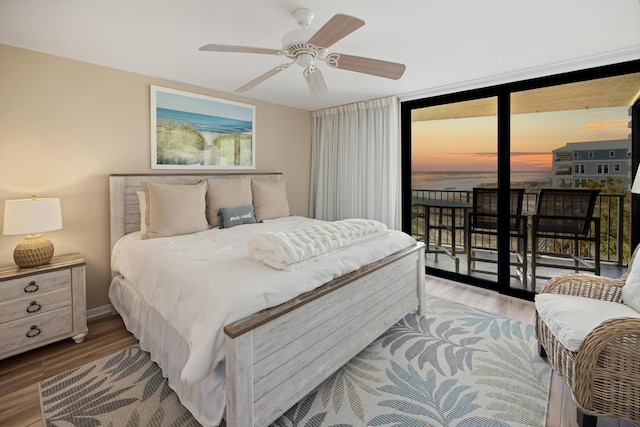 bedroom featuring baseboards, wood finished floors, a ceiling fan, and access to outside