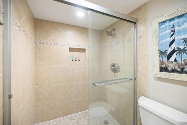 bathroom featuring a shower stall and toilet