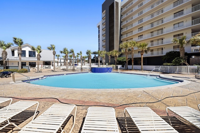 pool with a patio area and fence