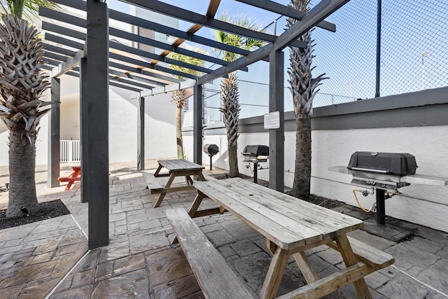 view of patio featuring outdoor dining space, a pergola, and grilling area