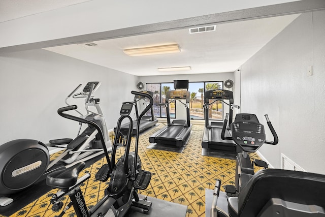 exercise room with baseboards and visible vents