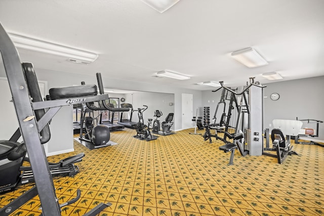 exercise room with baseboards, visible vents, and carpet floors