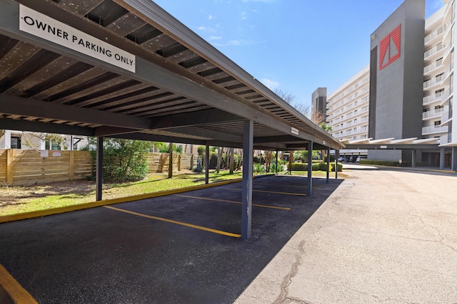 covered parking lot featuring fence