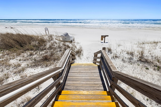 view of community featuring a beach view and a water view