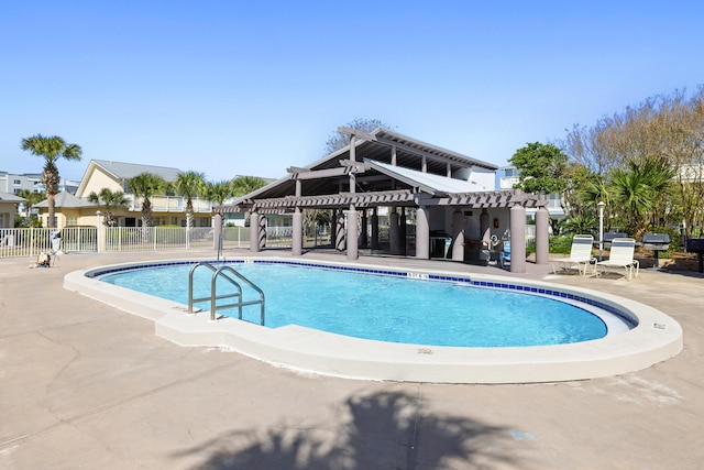 pool with a patio area, a pergola, and fence