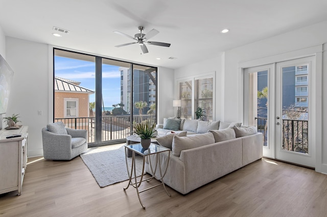 living area with visible vents, floor to ceiling windows, light wood-type flooring, recessed lighting, and french doors