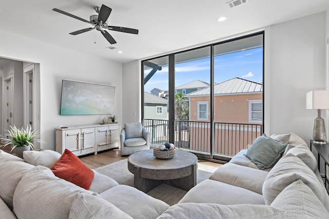 living room with recessed lighting, expansive windows, wood finished floors, and a ceiling fan