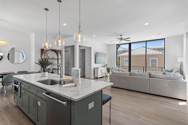 kitchen featuring a sink, light wood-style floors, appliances with stainless steel finishes, and open floor plan