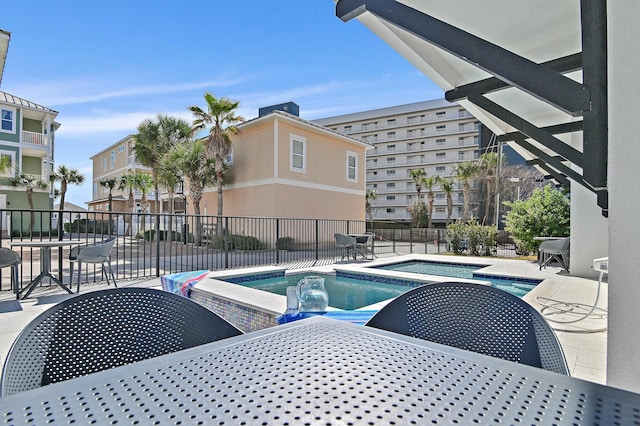 pool with a patio area, a hot tub, and fence