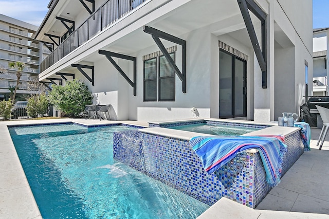 view of swimming pool with a pool with connected hot tub and a patio area